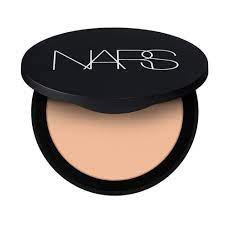 Open black Nars compact showing light peach pressed powder inside.